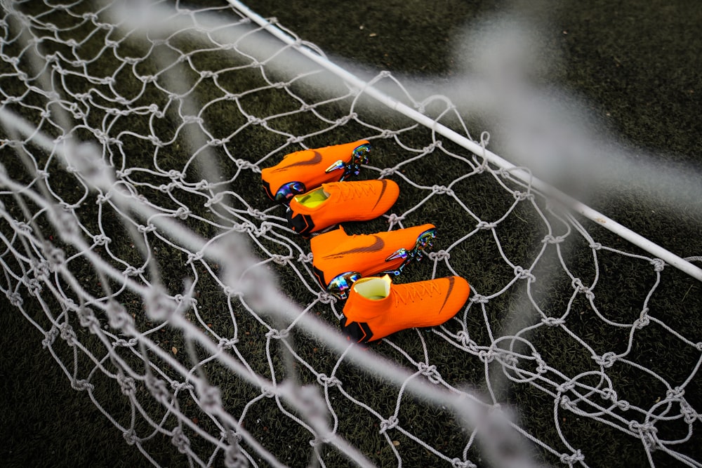 two pairs of orange Nike cleats on goalie