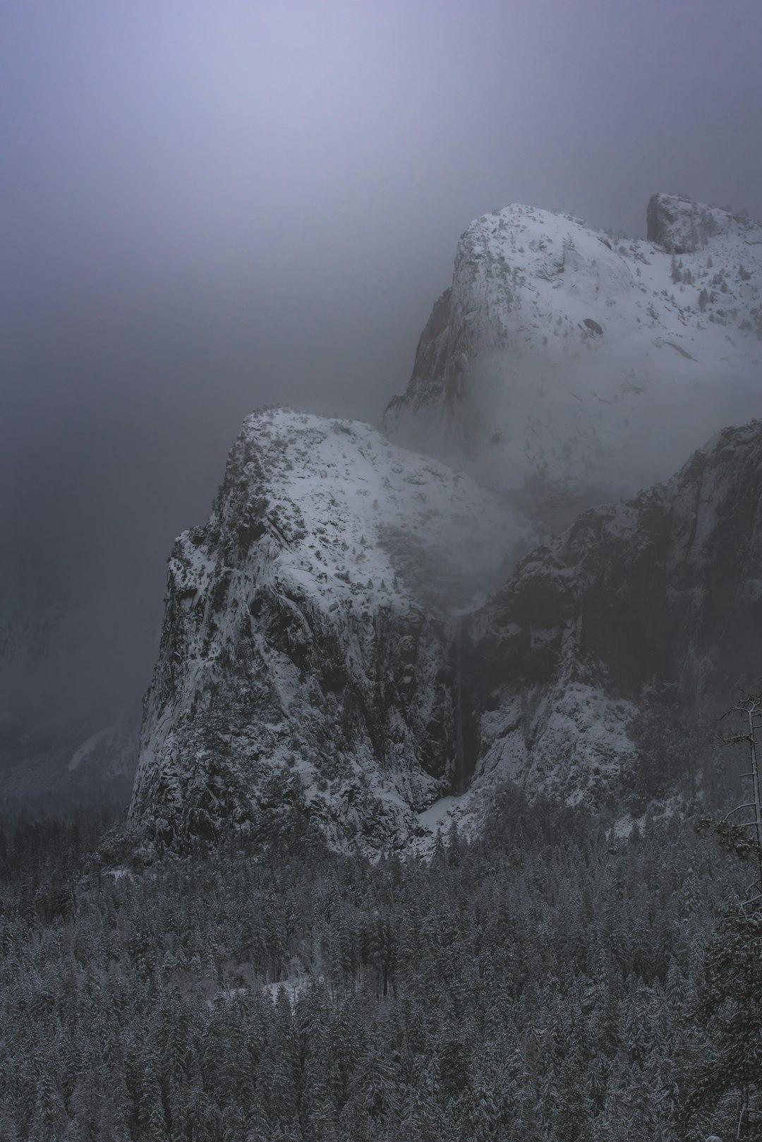 snow covered mountain under cloudy sky