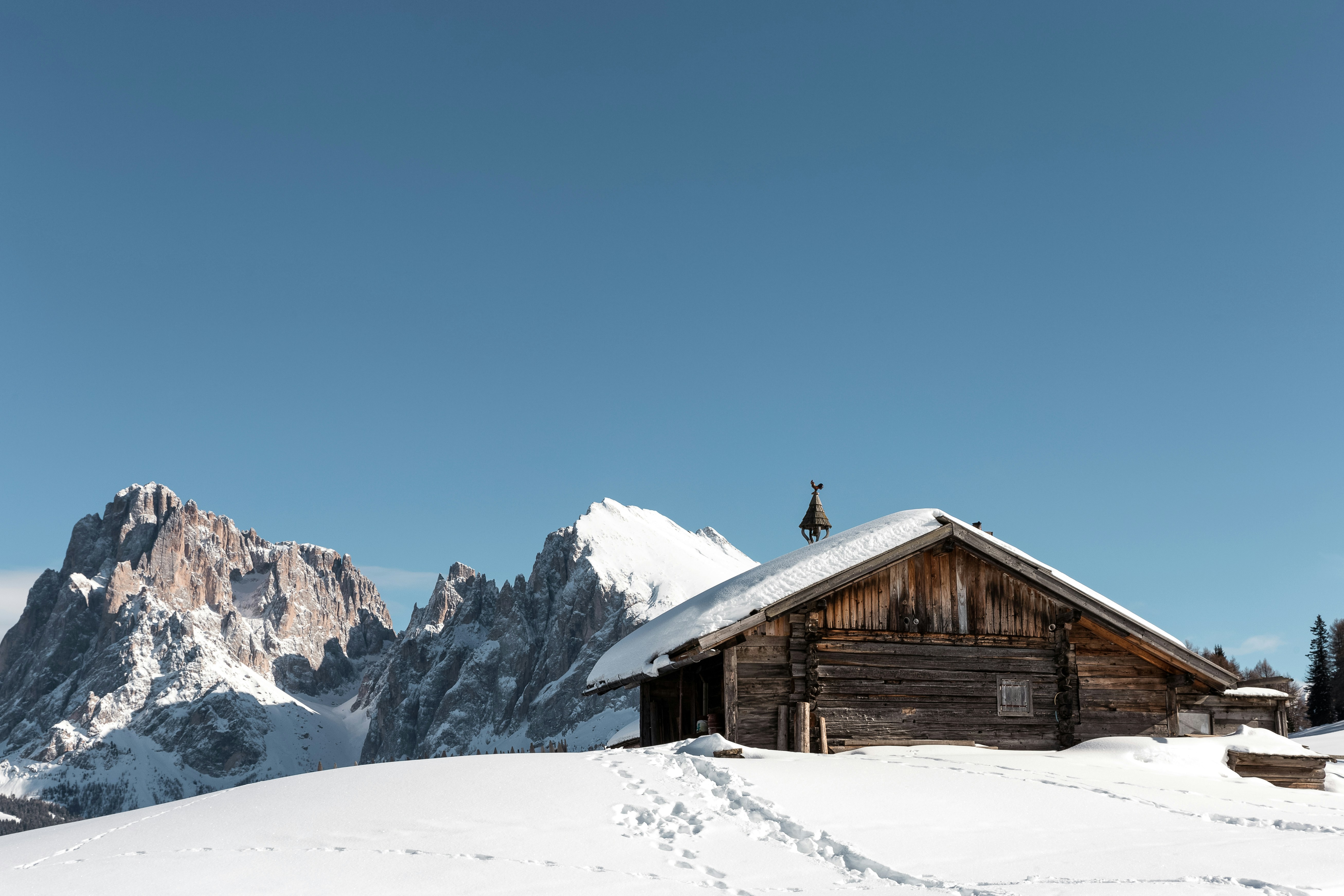 Casa di legno marrone all'interno della catena montuosa durante il giorno