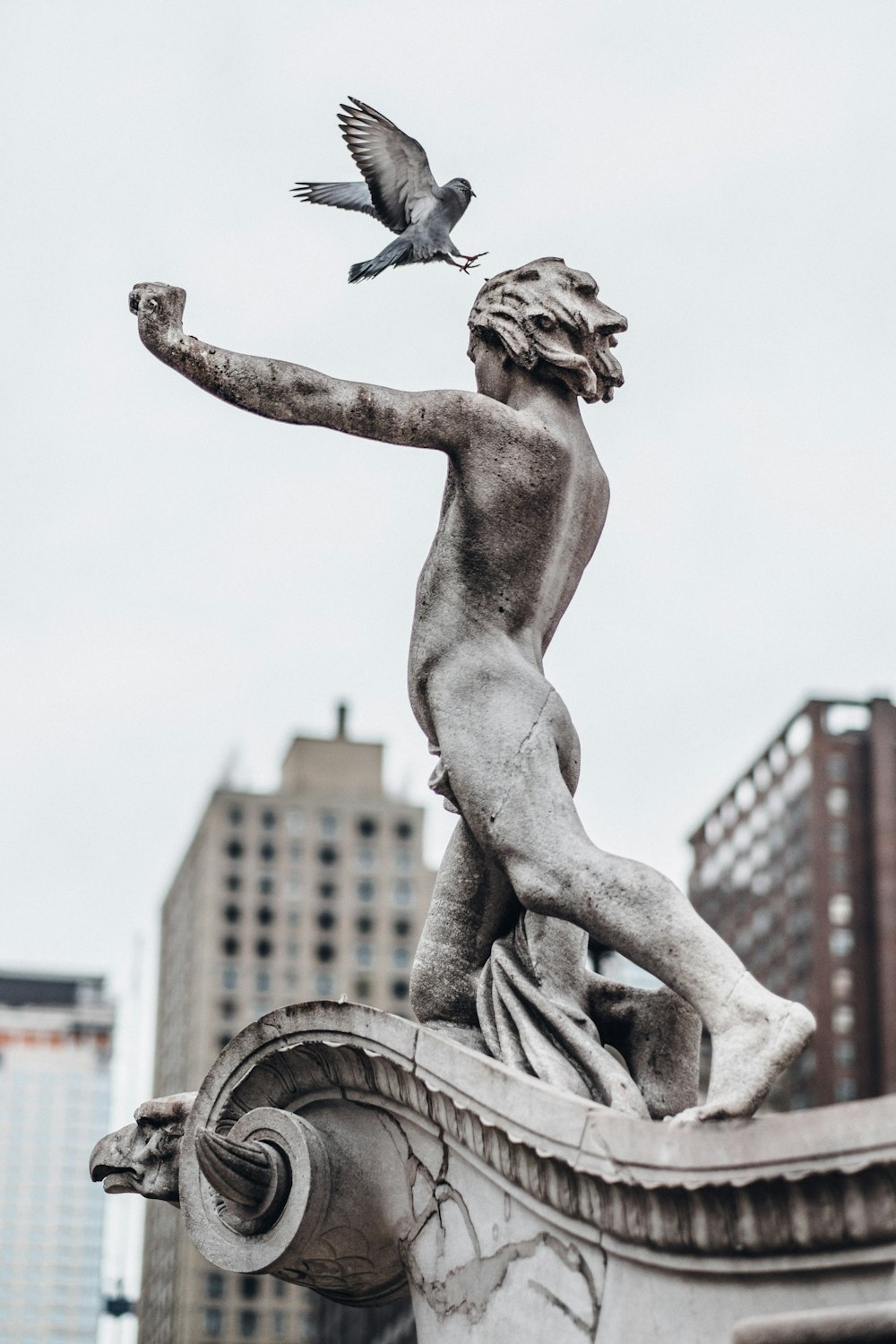 Estatua de hormigón del hombre y del pájaro