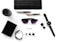 Various everyday items neatly arranged on a white surface, including a black wallet, wristwatch, sunglasses, pen, notebook, portable speaker, bracelet, ink bottle caps, and a card labeled 'Essentials.'