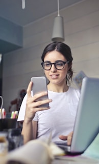 woman in white shirt using smartphone