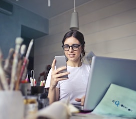 woman in white shirt using smartphone