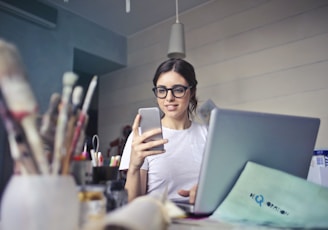 woman in white shirt using smartphone