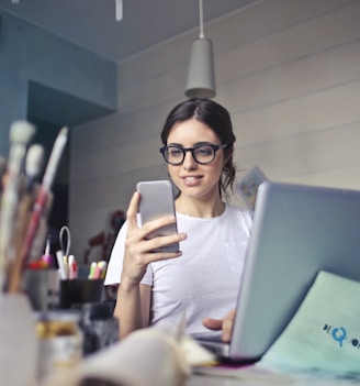 woman in white shirt using smartphone