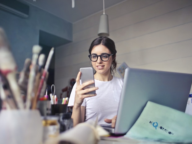 woman in white shirt using smartphone