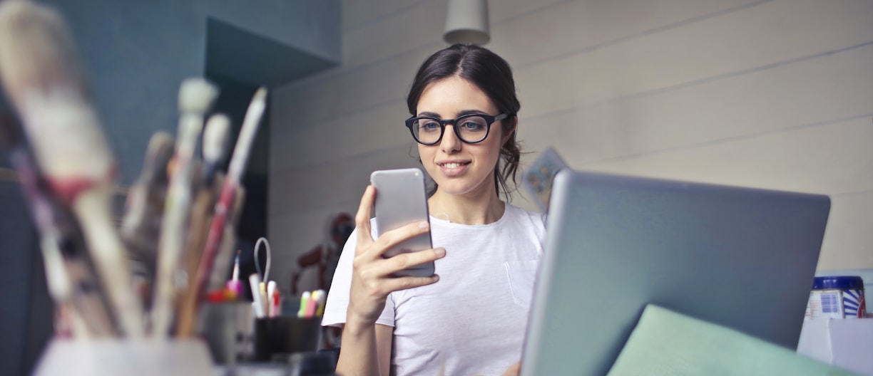 woman in white shirt using smartphone