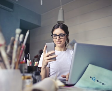 woman in white shirt using smartphone