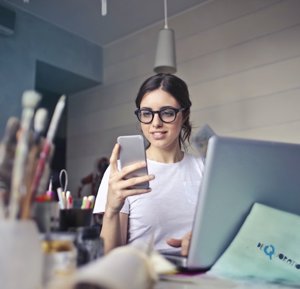 woman in white shirt using smartphone