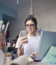 woman in white shirt using smartphone