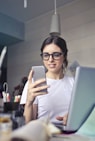 woman in white shirt using smartphone