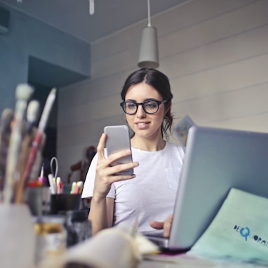 woman in white shirt using smartphone