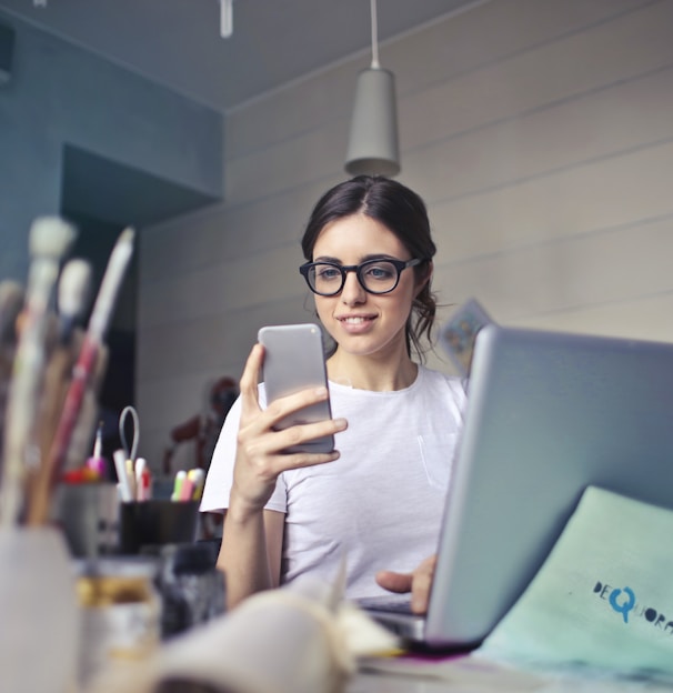 woman in white shirt using smartphone