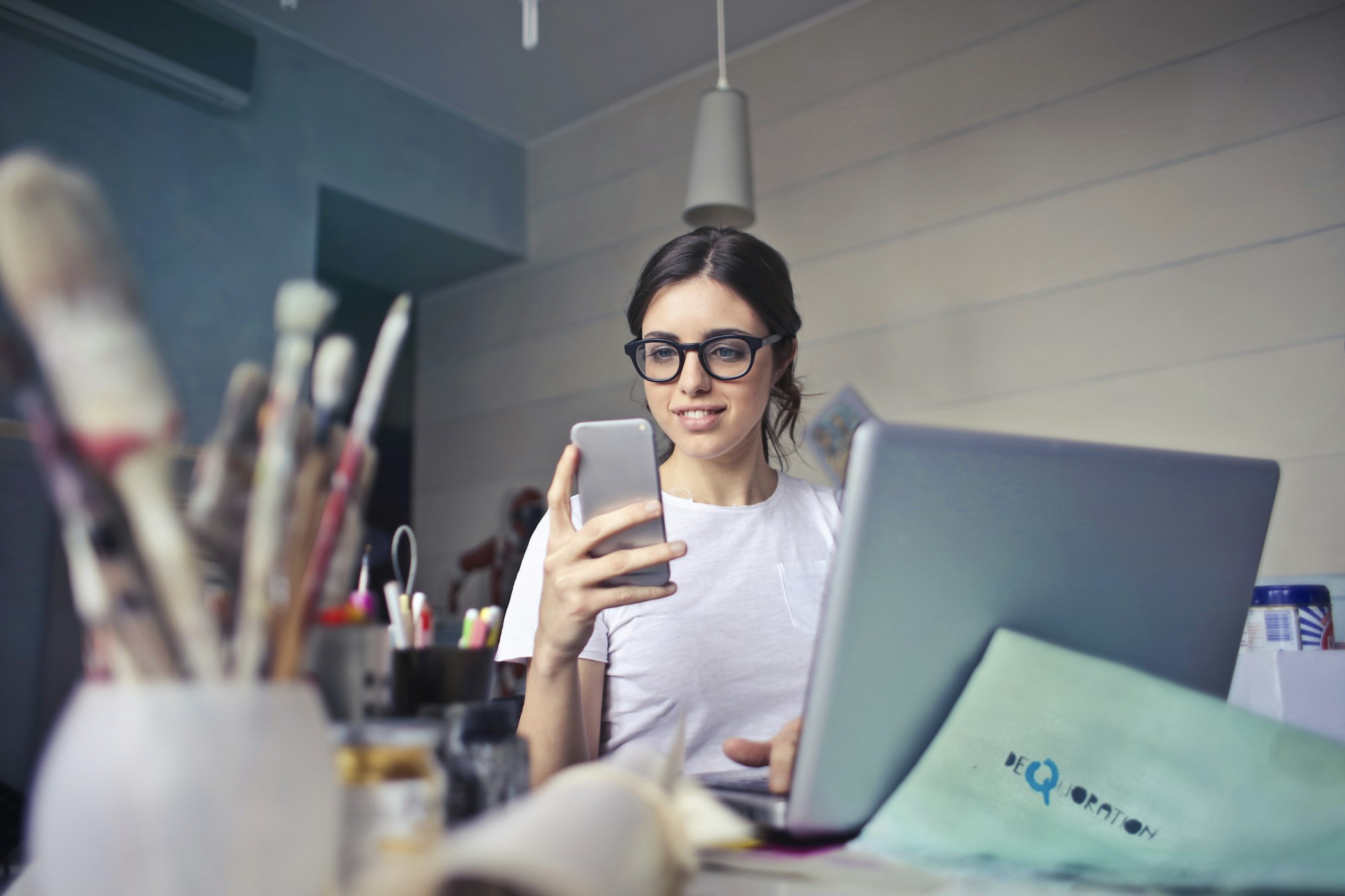 Woman at work using her cell phone to update and manage material safety data sheets online.