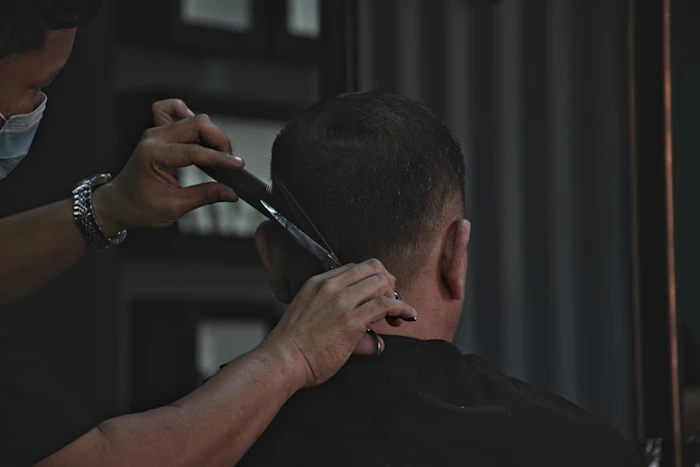 Barbero cortando cabello con tijeras
