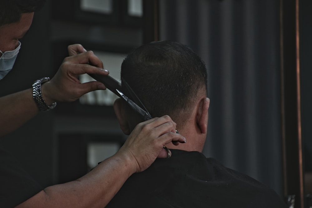 barber cutting man's hair