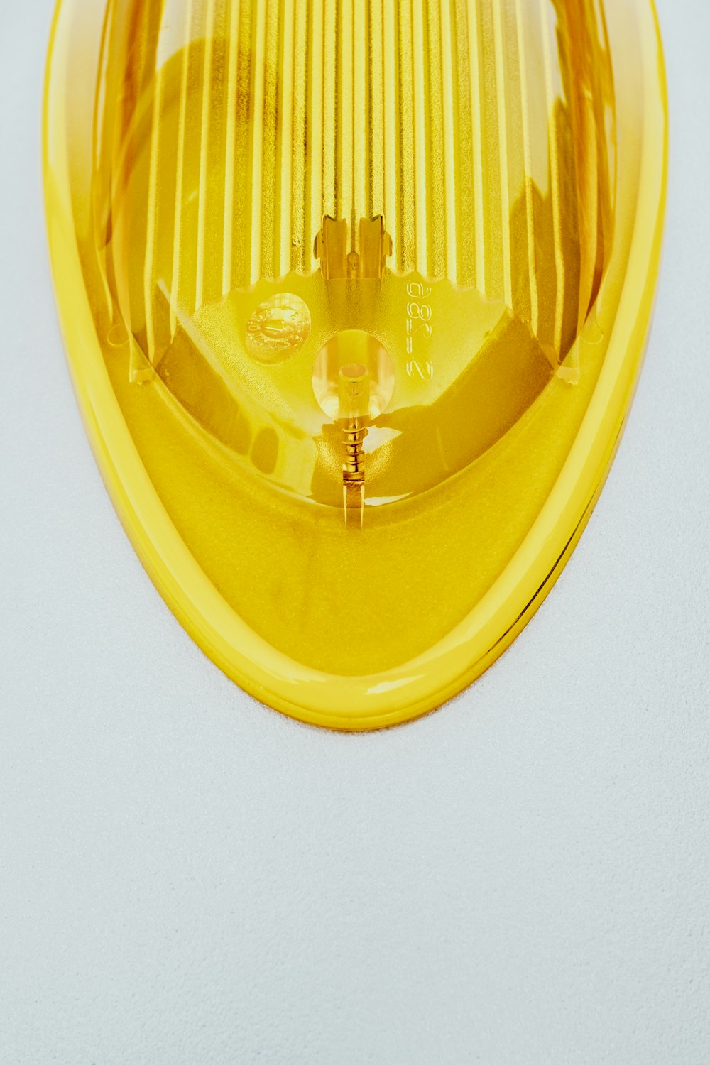 a close up of a yellow light on a white surface