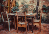 A rustic outdoor patio set with a wooden table and chairs.