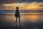 woman standing near the seashore during golden hour