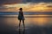 woman standing near the seashore during golden hour