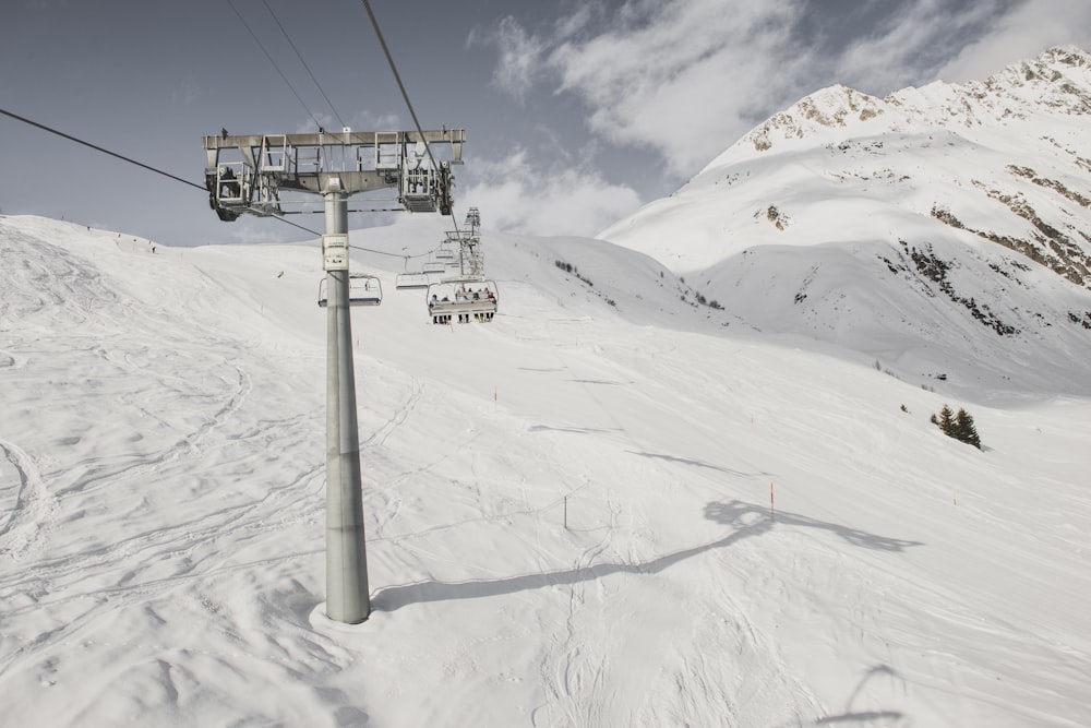 gray steel cable car post under cloudy sky during snow season