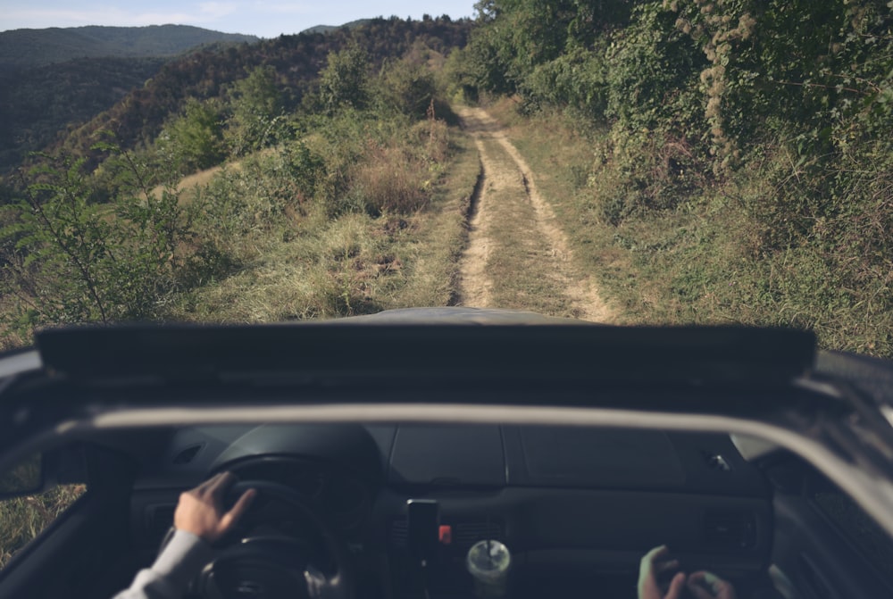 a person driving a car down a dirt road