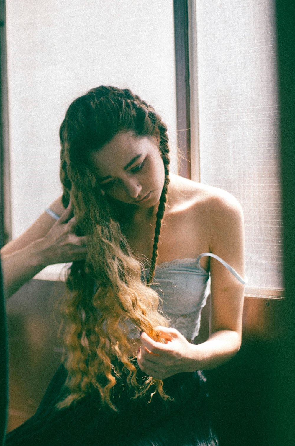 woman wearing blue camisole holding hair