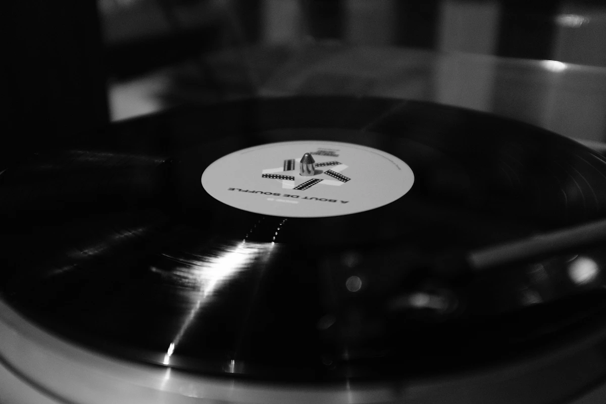 A record spinning on a turntable in a dim bar, warm lamplight across the deck, at The Copper Hour.