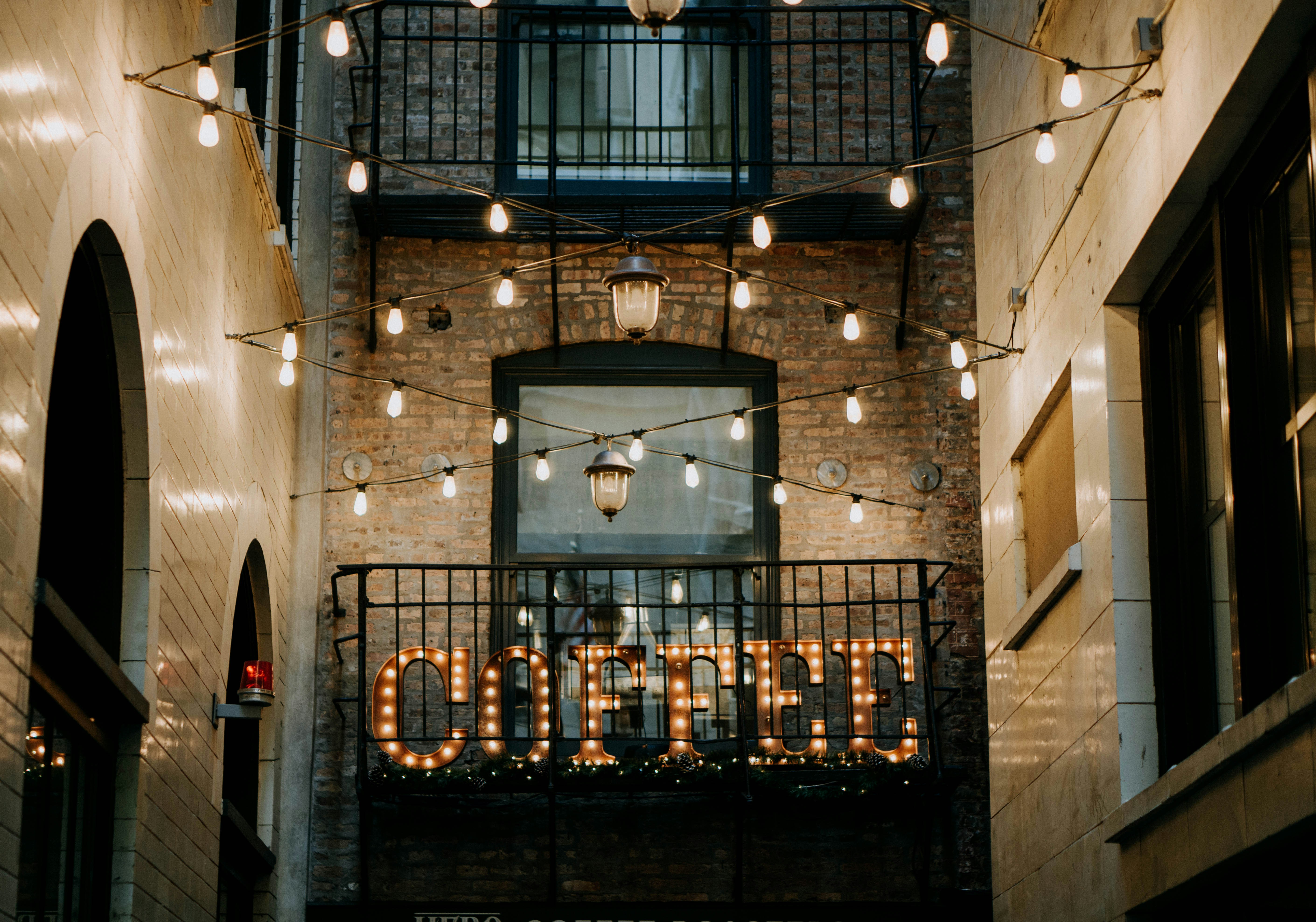 brown Coffee LED signage between buildings