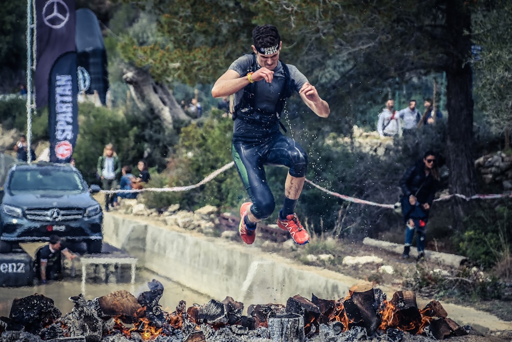 man jumping on flaming charcoal