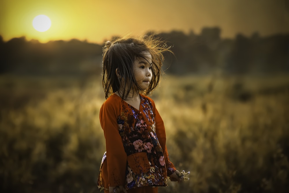 Menina em pé perto do campo