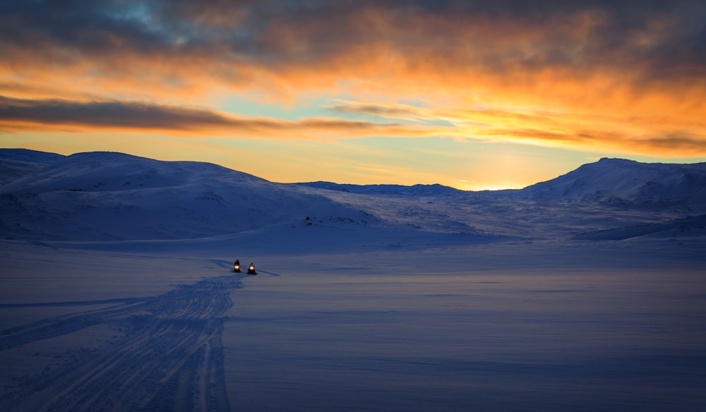 snow capped mountain and field during sunrise