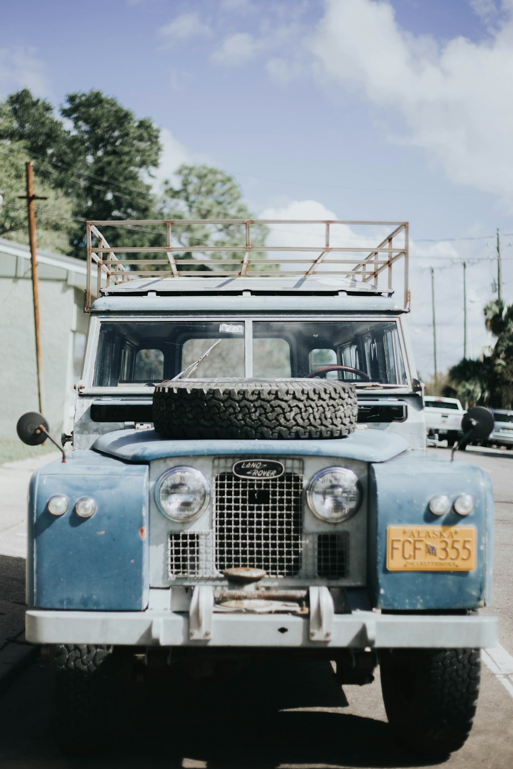 photography of blue vehicle parked on road