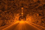 A tunnel entrance carved into a rocky hillside, illuminated by soft lighting.
