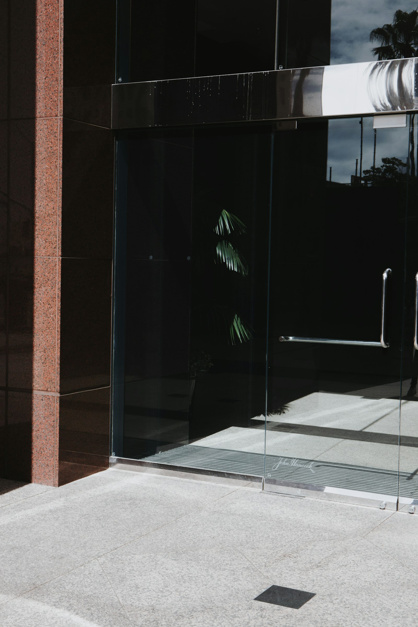 Glass storefront door reflecting the street outside