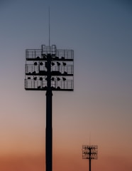 silhouette of two spot light tower