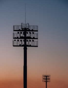 silhouette of two spot light tower