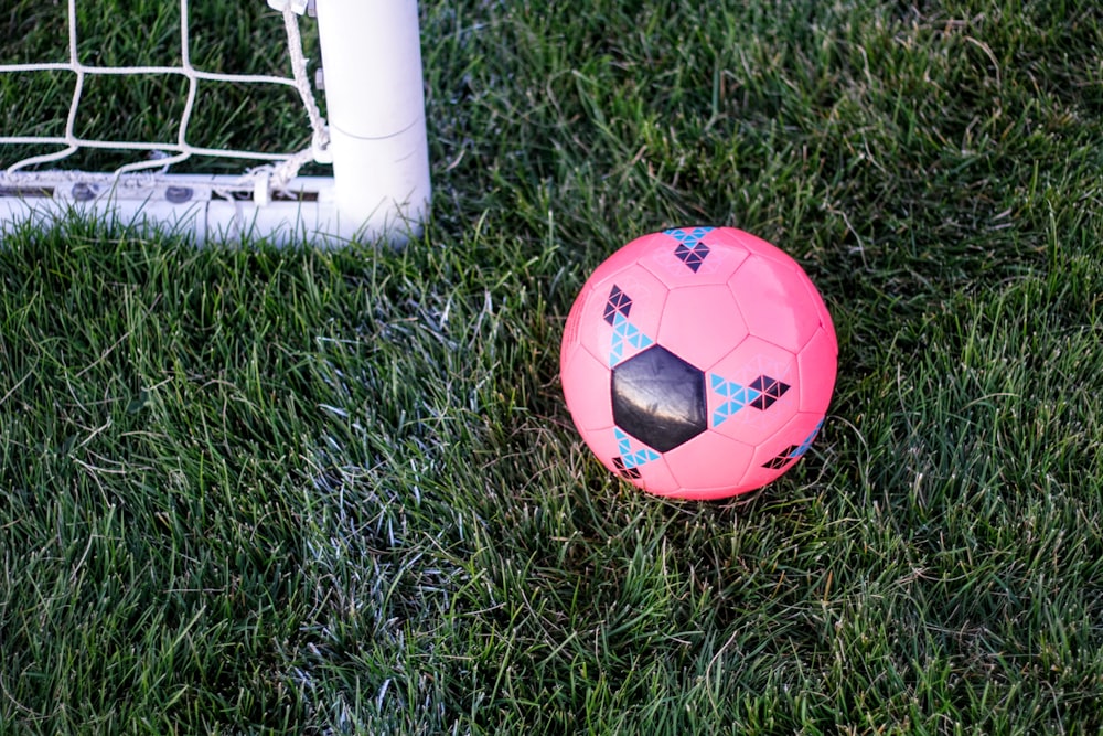 bola de borracha rosa ao lado da rede do gol