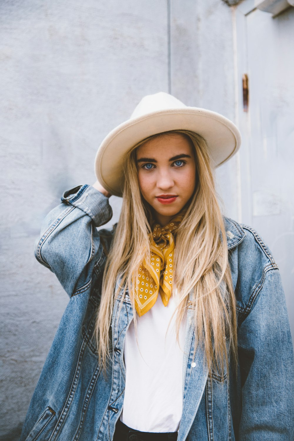 woman wearing blue denim jacket and white hat