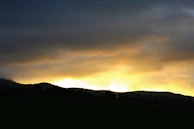 A panoramic view of a fiery Australian sunset over rugged outback hills
