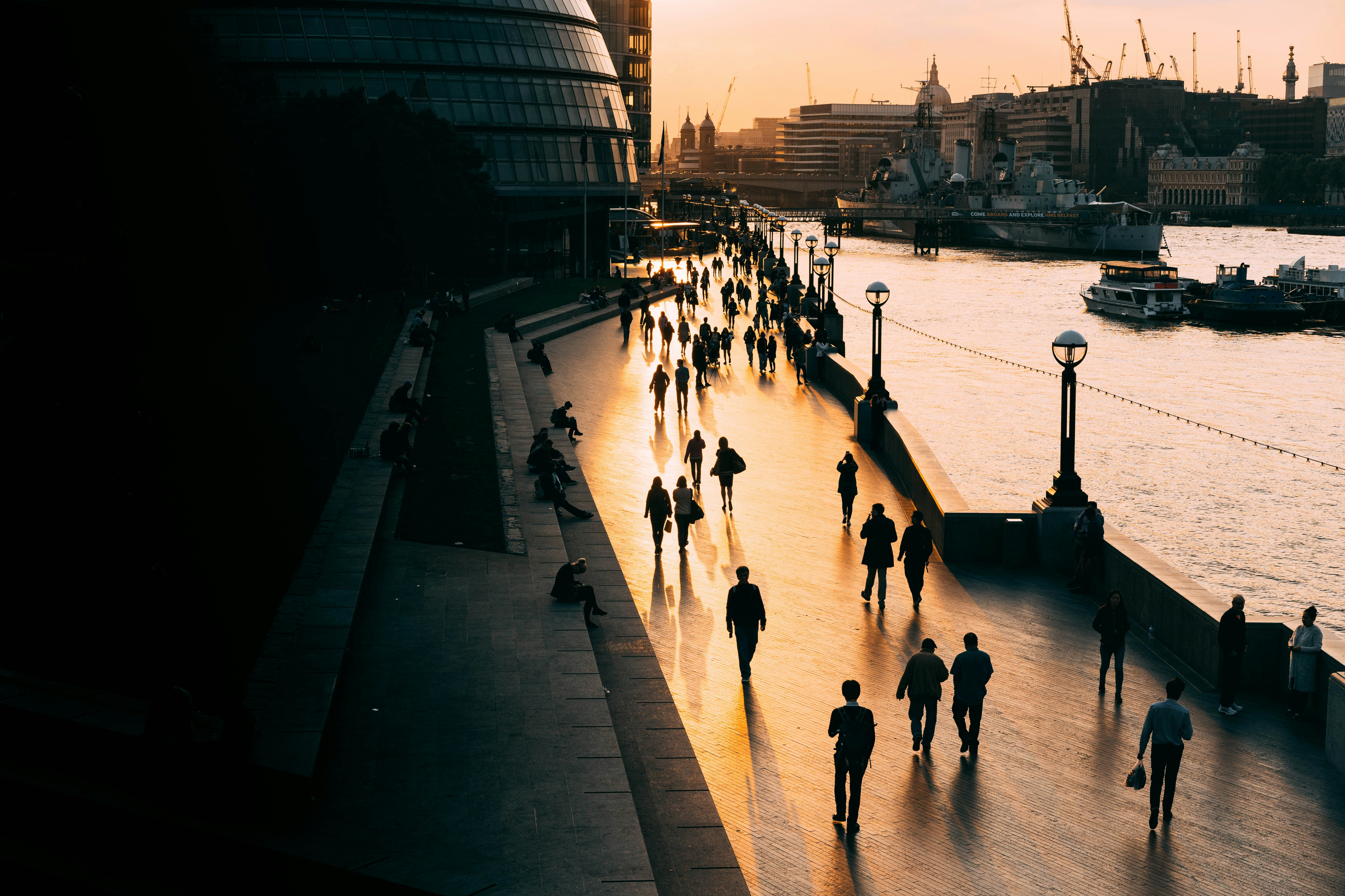 people walking on road near body of water