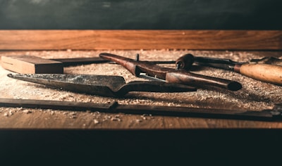 A close-up of well-used carpentry tools neatly arranged on a wooden workbench.