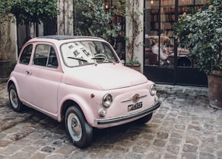 pink FIAT 500 on gray concrete floor