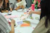 A small group gathered around a table, deeply engaged in an art session.
