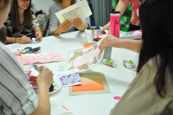 A group of smiling kids crafting colorful products together in a cozy room filled with art supplies.