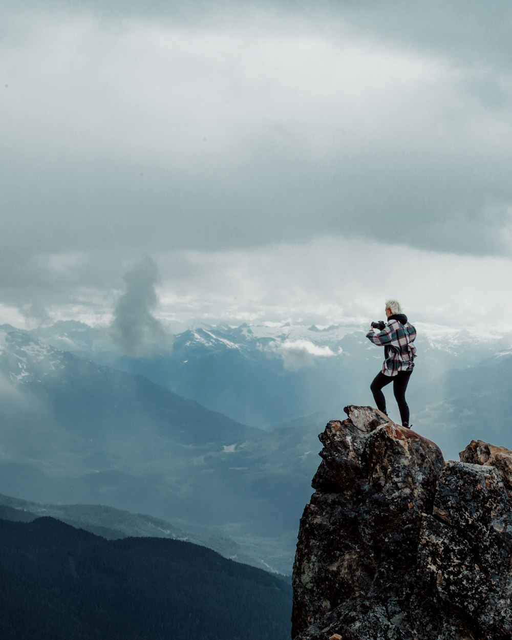 persona in piedi in cima alla montagna di roccia durante il giorno