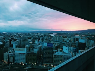 A scenic cityscape viewed from a high vantage point during sunset.