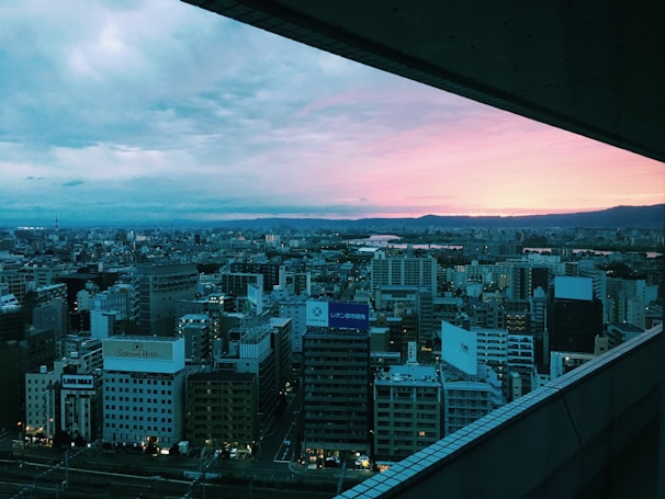 A scenic cityscape viewed from a high vantage point during sunset.