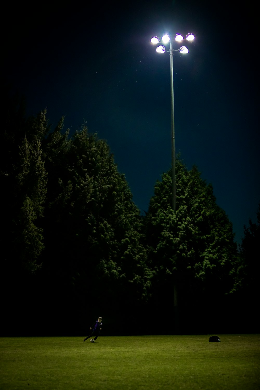 hombre jugando al fútbol durante la noche
