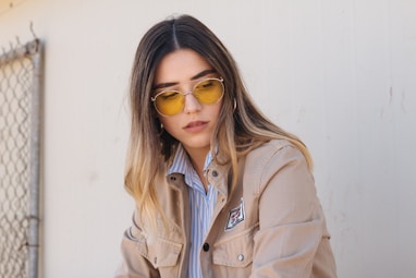 woman in brown button-up jacket near white painted wall